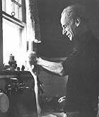 Joseph Cornell in his kitchen, in Flushing, NY, c. 1965.