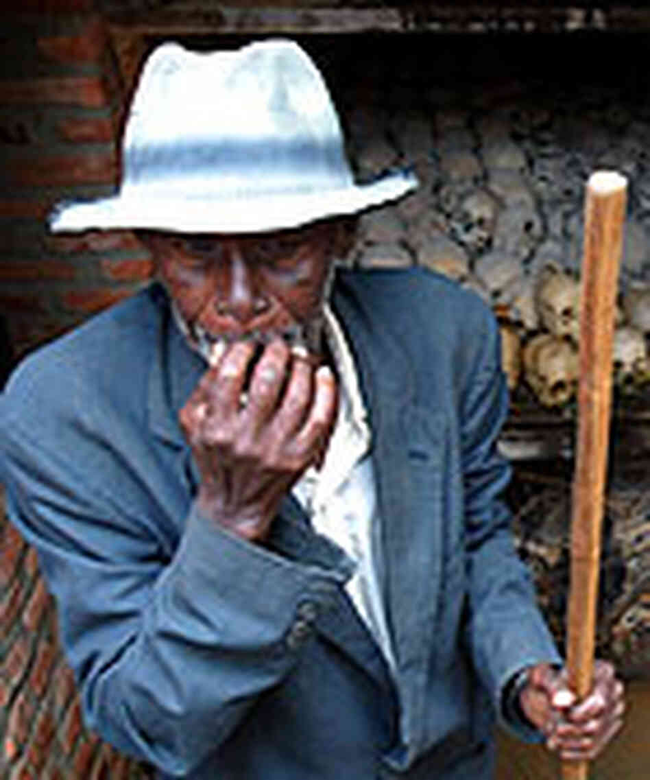 A Rwandan worker cleans a mass grave outside a church in Nyanza. A Rwandan worker cleans a mass grave outside a church in Nyanza.