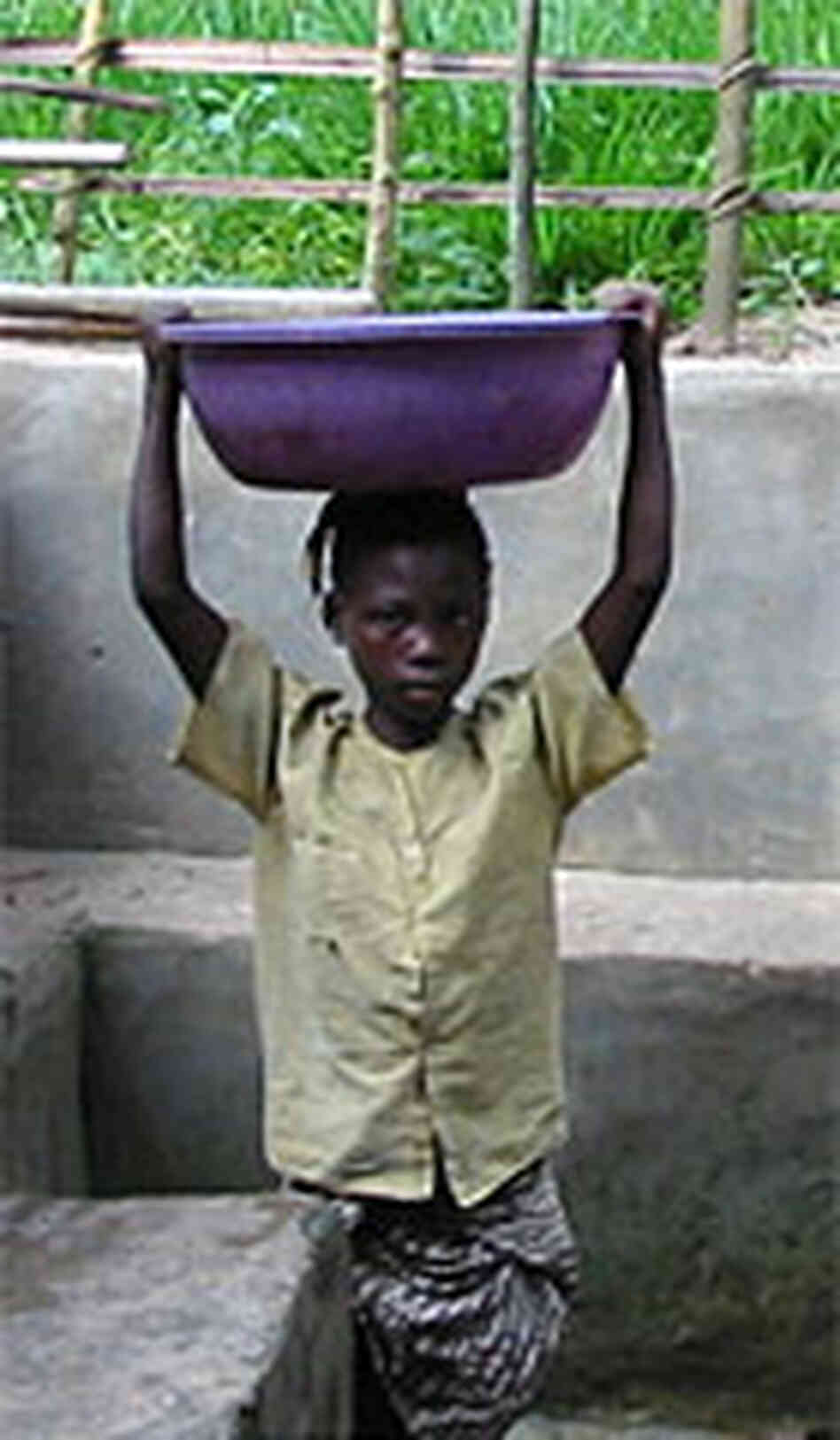 A girl hauls water in an open basin in the Congolese town of Kibombo. A girl hauls water in an open basin in the Congolese town of Kibombo.