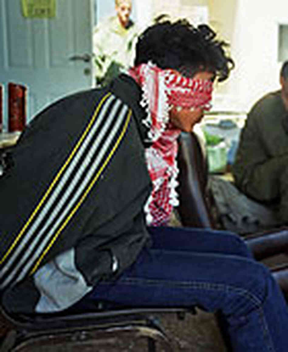 A blindfolded Palestinian held by Israeli troops in the West Bank city of Hebron. A blindfolded Palestinian held by Israeli troops in the West Bank city of Hebron.