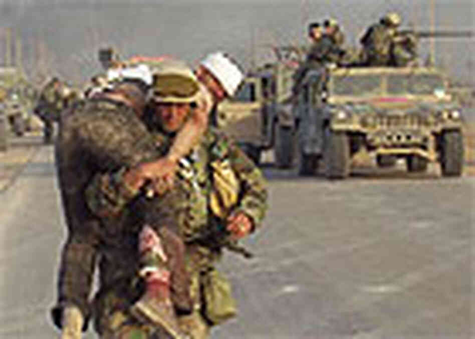 A Marine carries a wounded Iraqi. A Marine carries a wounded Iraqi.