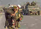 A Marine carries a wounded Iraqi. A Marine carries a wounded Iraqi.