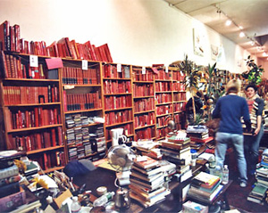 Virginia White and Jill Manthei carry a stack of books for the red section.