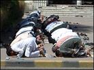 The faithful spill out of a Kuwait City mosque to pray on the sidewalk for Friday prayers. The faithful spill out of a Kuwait City mosque to pray on the sidewalk for Friday prayers.