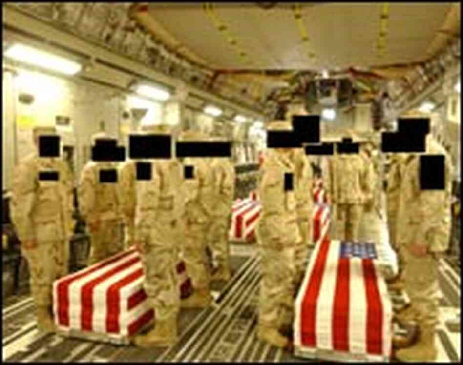 Military personnel stand along rows of caskets inside a military transport. Military personnel stand along rows of caskets inside a military transport.