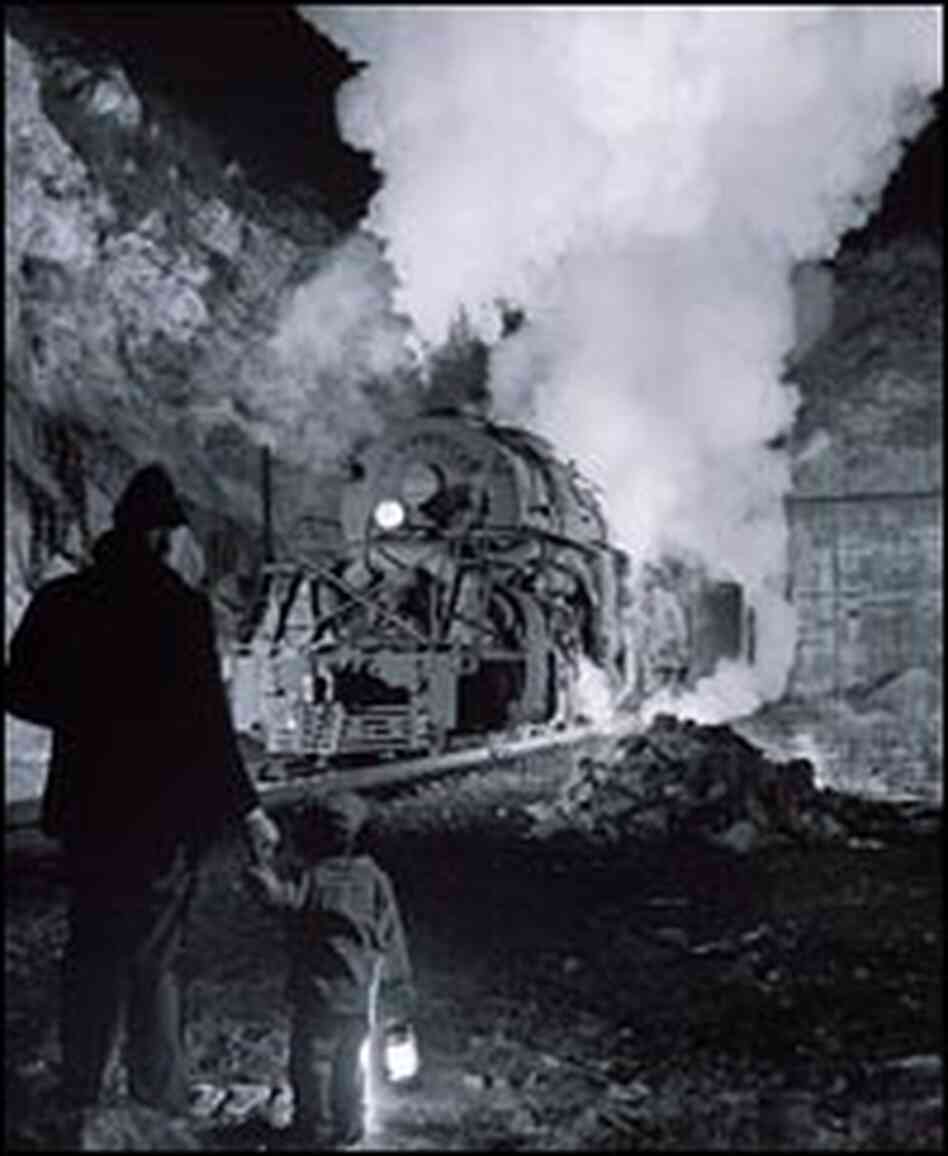A father and his son watch a coal extra going westbound out of the Montgomery Tunnel. A father and his son watch a coal extra going westbound out of the Montgomery Tunnel.