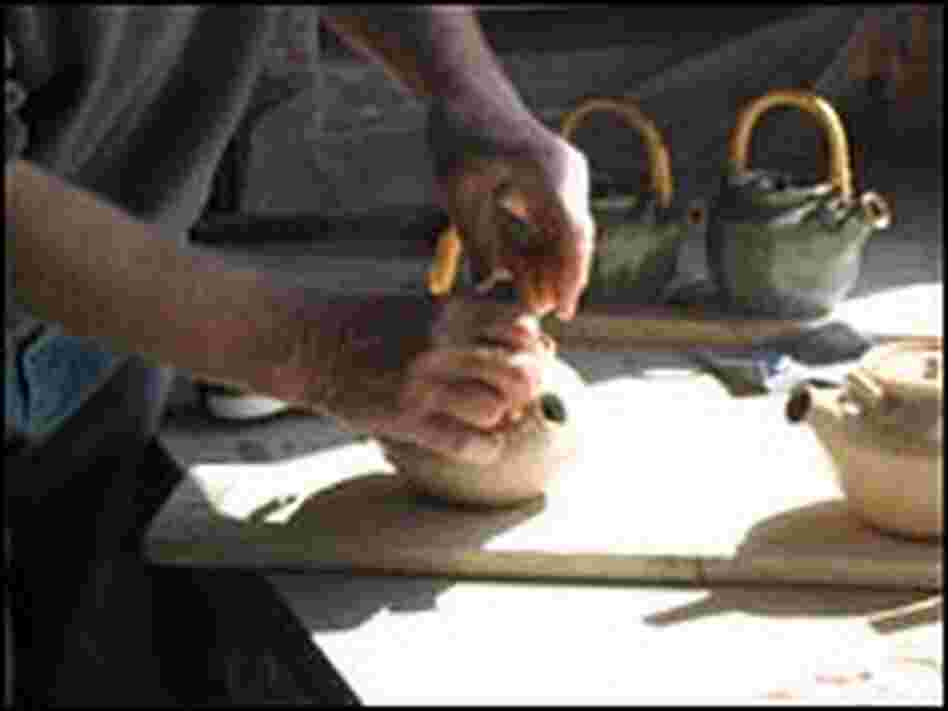MacKenzie attaches a handle to a teapot. MacKenzie attaches a handle to a teapot.