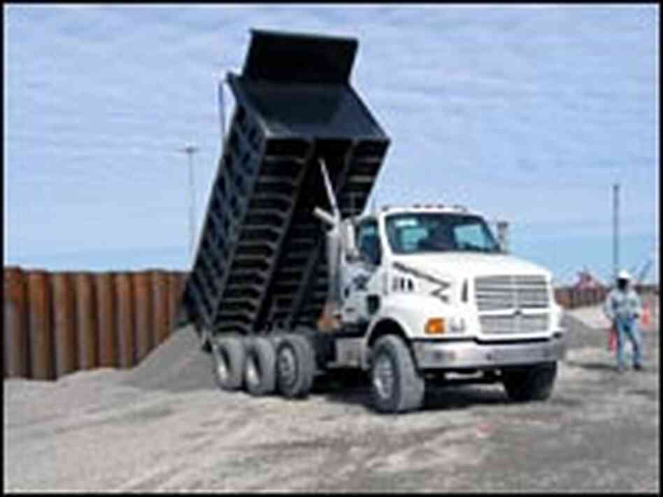 A dump truck pours gravel A dump truck pours gravel