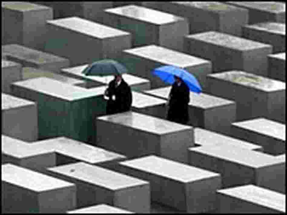People walk between the concrete blocks of the Holocaust memorial. People walk between the concrete blocks of the Holocaust memorial.