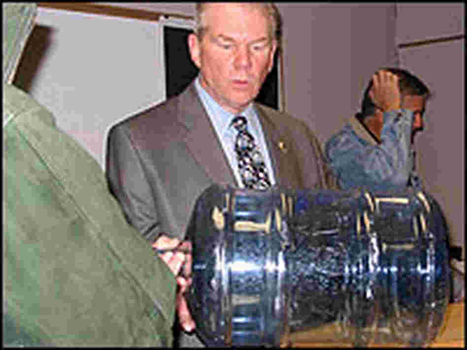 District attorney Mike Ramsey shows reporters the type of water jug from which Carrington was forced District attorney Mike Ramsey shows reporters the type of water jug from which Carrington was forced