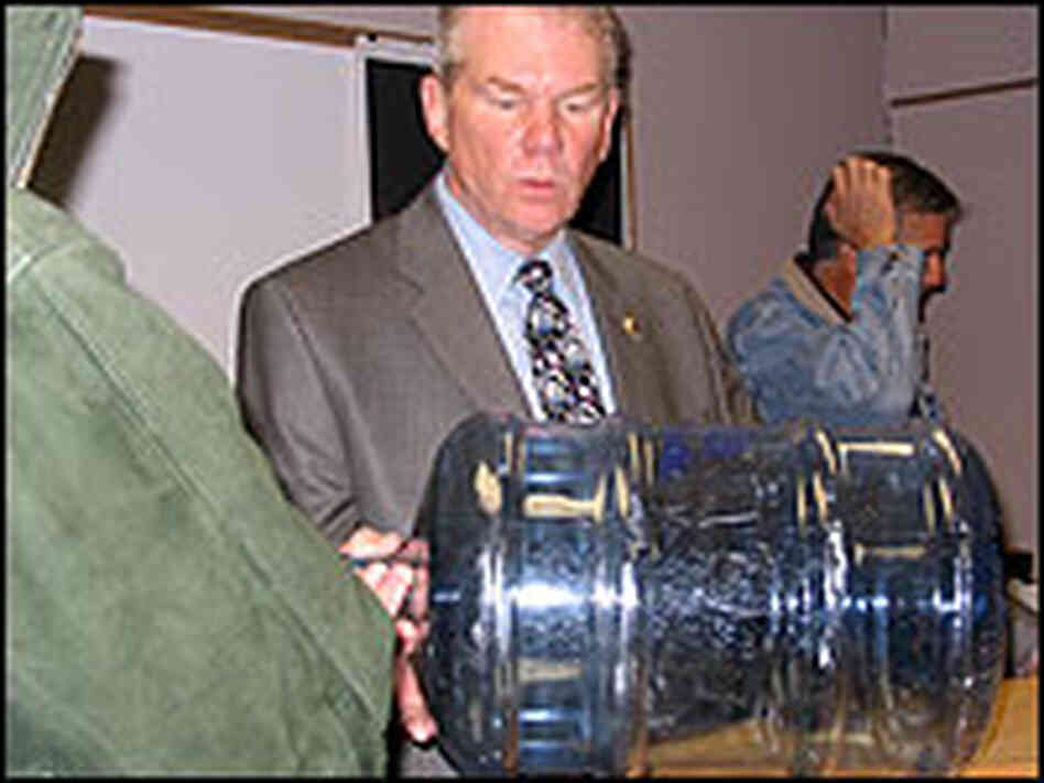 District attorney Mike Ramsey shows reporters the type of water jug from which Carrington was forced District attorney Mike Ramsey shows reporters the type of water jug from which Carrington was forced