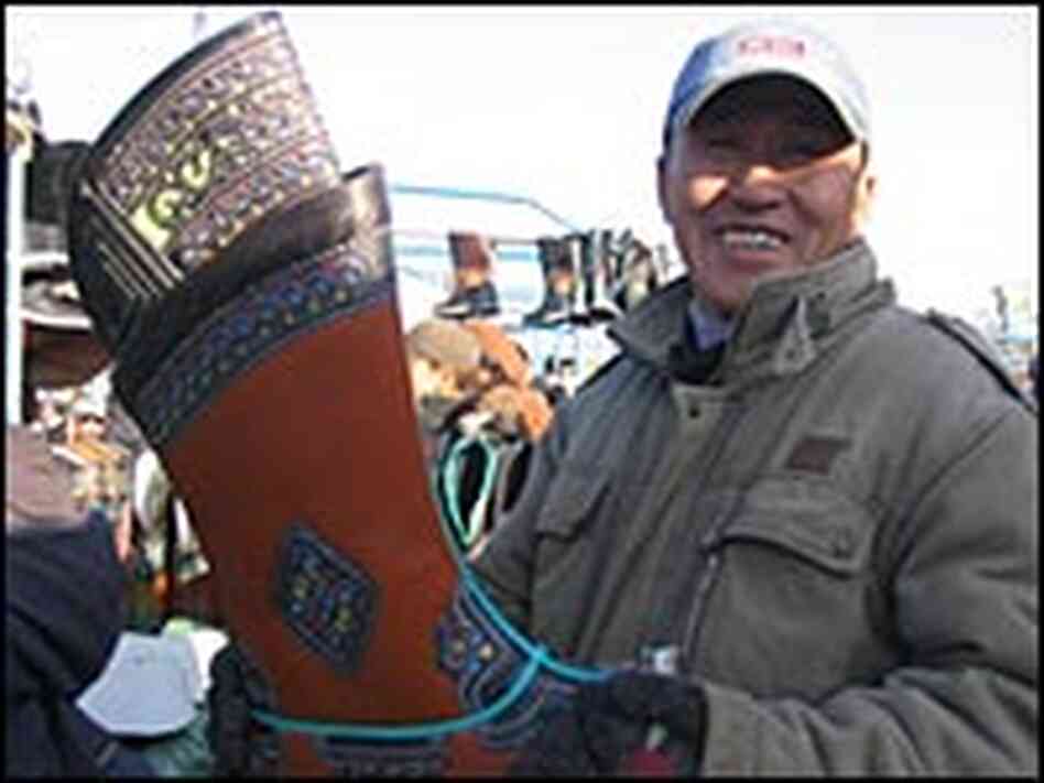 Boot merchant Nyamad shows off one of his gigantic Mongolian boots. Boot merchant Nyamad shows off one of his gigantic Mongolian boots.
