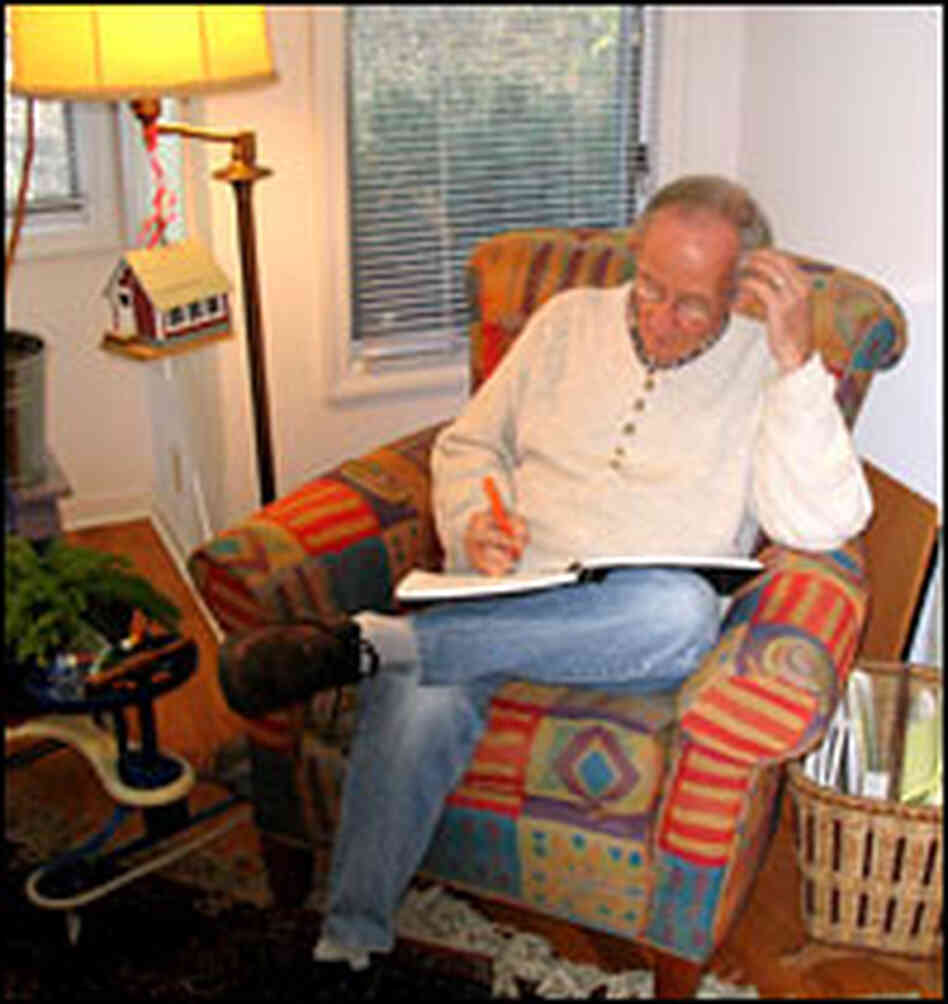 Kooser sits in his chair with a notebook in his lap.