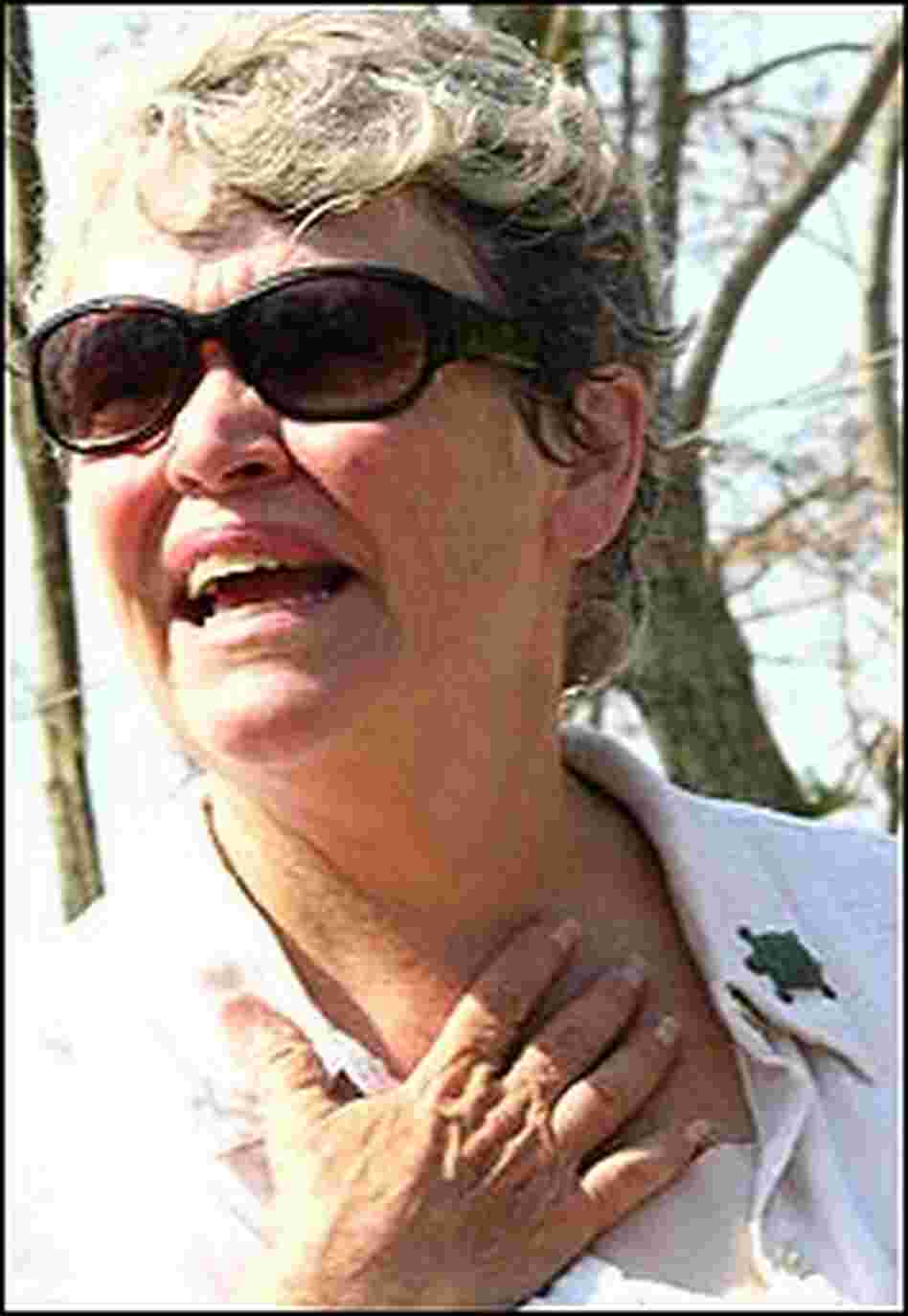Mary Anderson Pickard, wearing sunglasses, holds a hand to her throat.