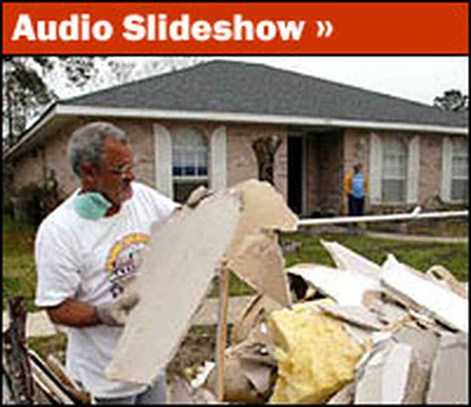 Eric Arnaud clears debris from his home on Honeysuckle Lane. Eric Arnaud clears debris from his home on Honeysuckle Lane.