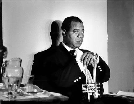 Louis Armstrong, caught in a reflective moment, his shadow against a white wall.