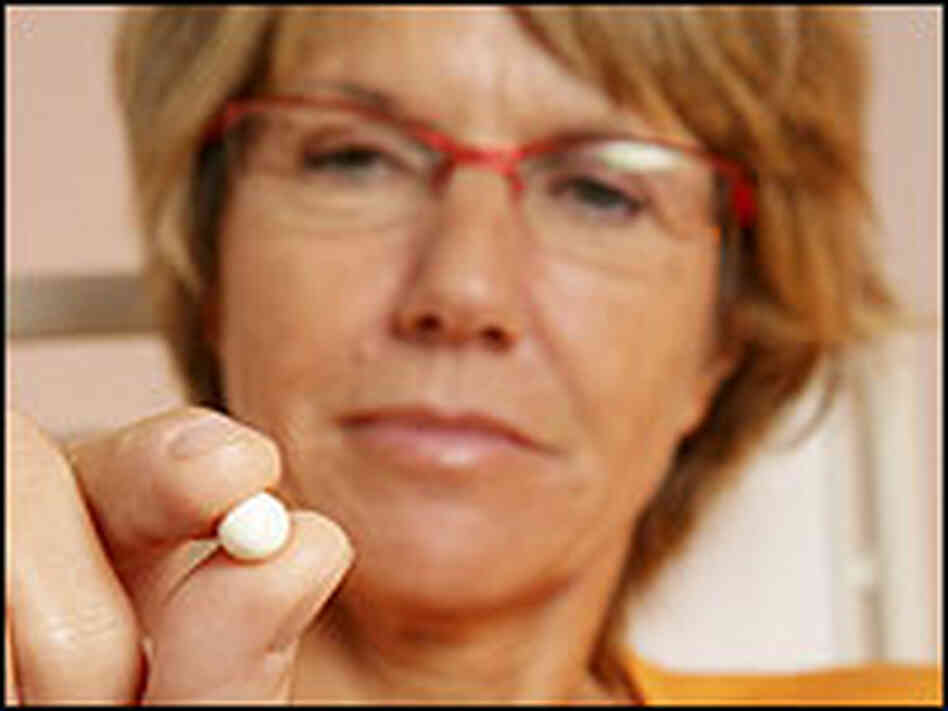 A woman holding a hormone therapy pill. A woman holding a hormone therapy pill.