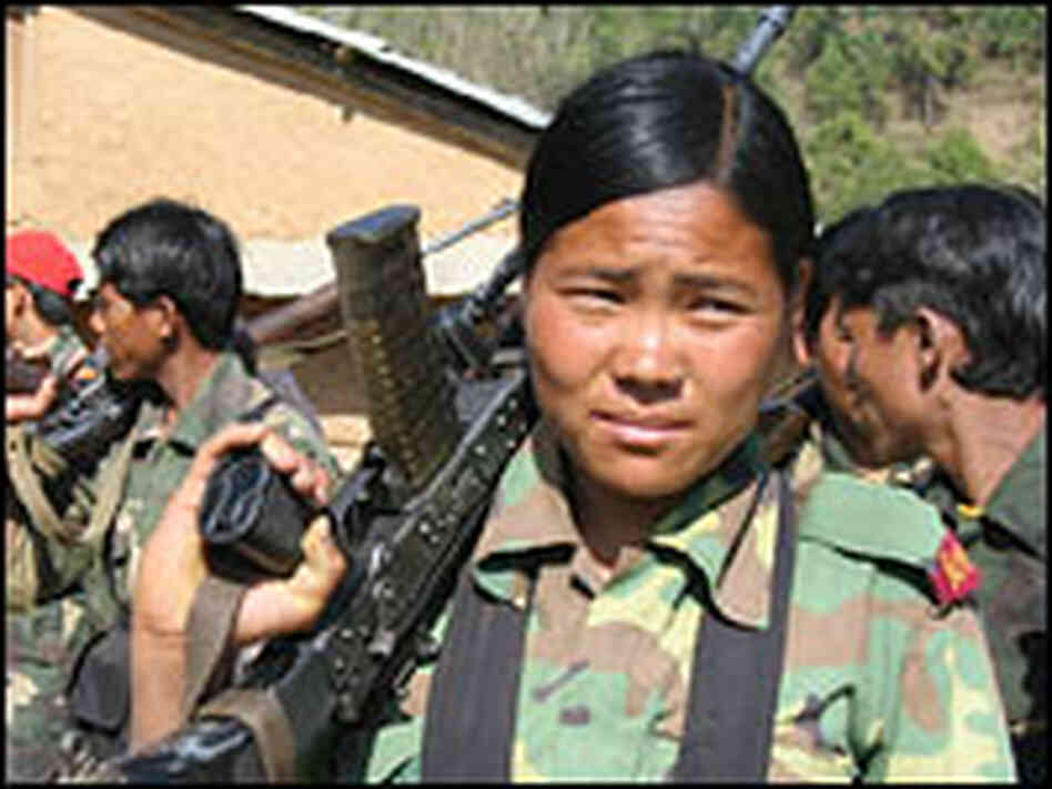 A communist insurgent stands with other soldiers in preparation for a Maoist event