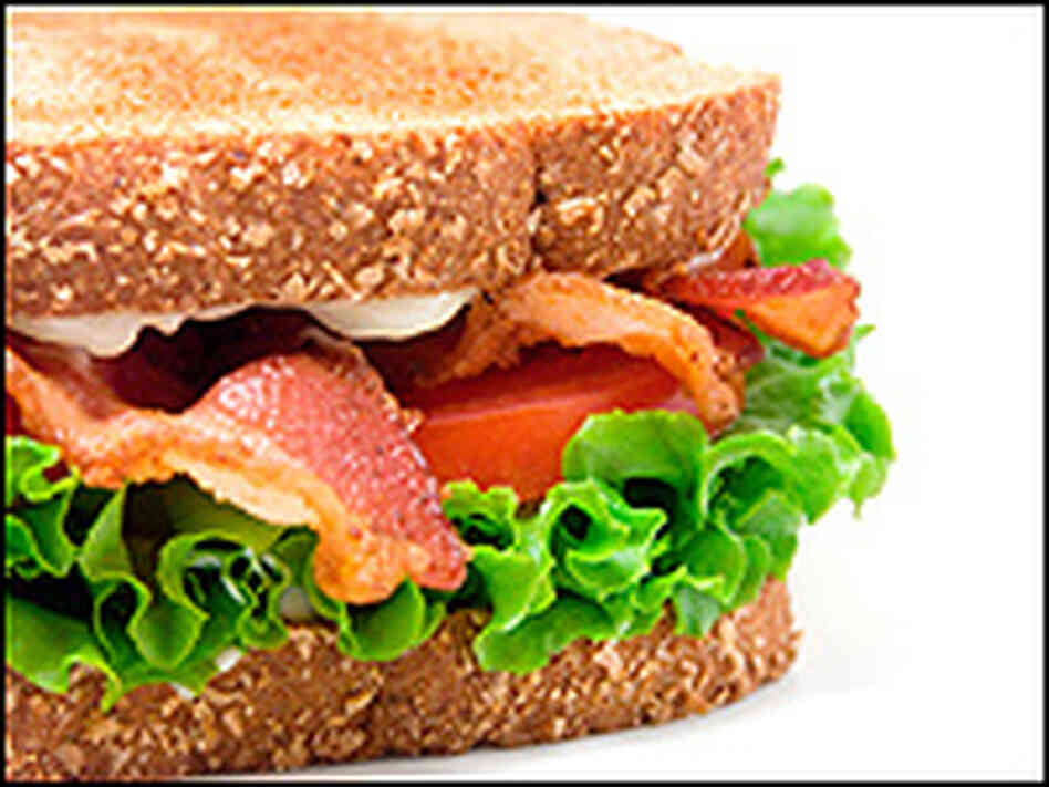 A bacon, lettuce and tomato sandwich with plenty of mayo visible.