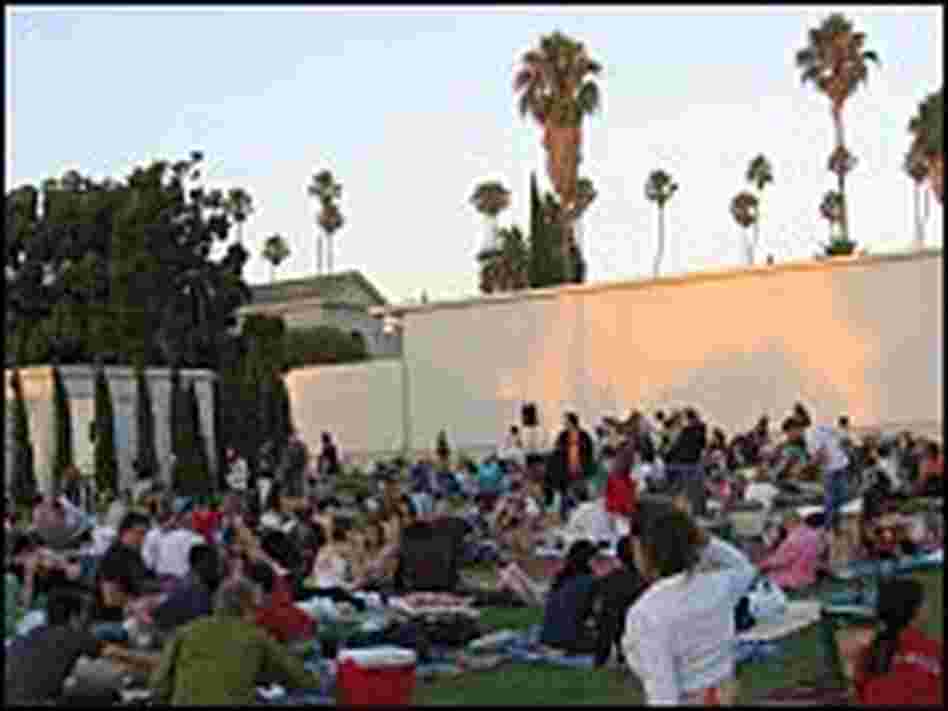 At sunset, nearly the entire lawn at the rear of the cemetery's main mausoleum is covered