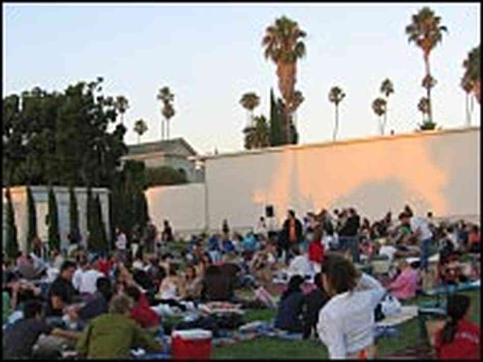 At sunset, nearly the entire lawn at the rear of the cemetery's main mausoleum is covered