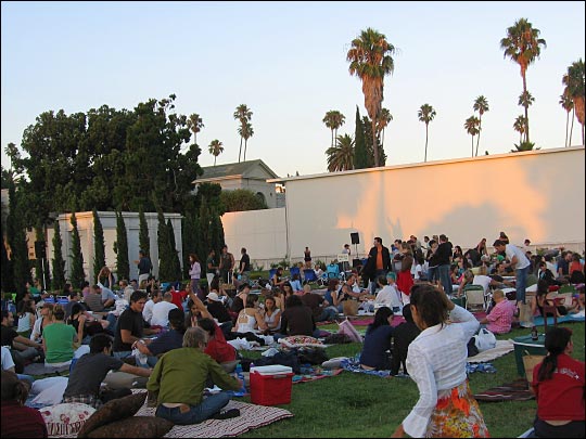 At sunset, nearly the entire lawn at the rear of the cemetery's main mausoleum is covered