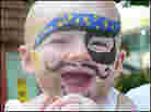 A small baby with face painted like a pirate. A small baby with face painted like a pirate.