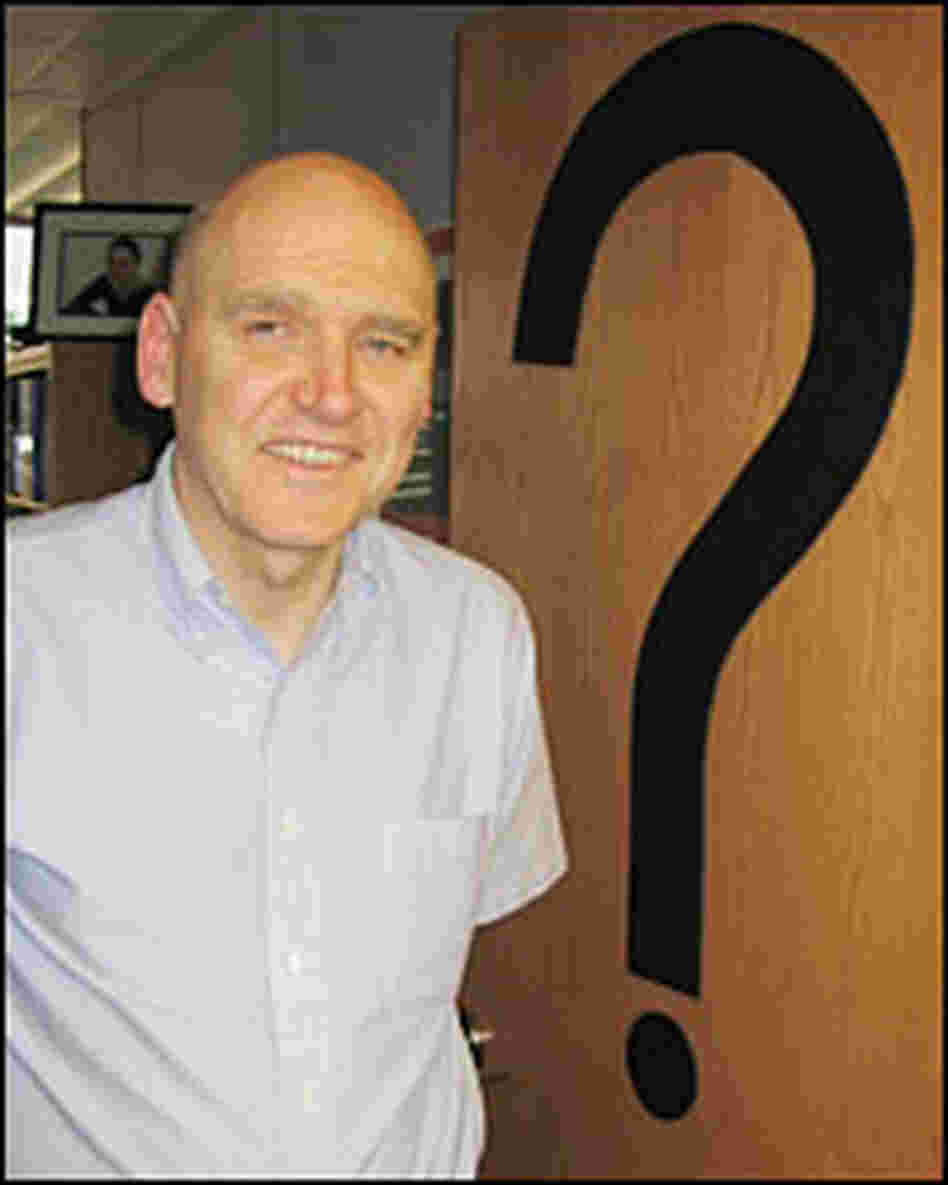 John Sawatsky stands in front of question mark on office door John Sawatsky stands in front of question mark on office door