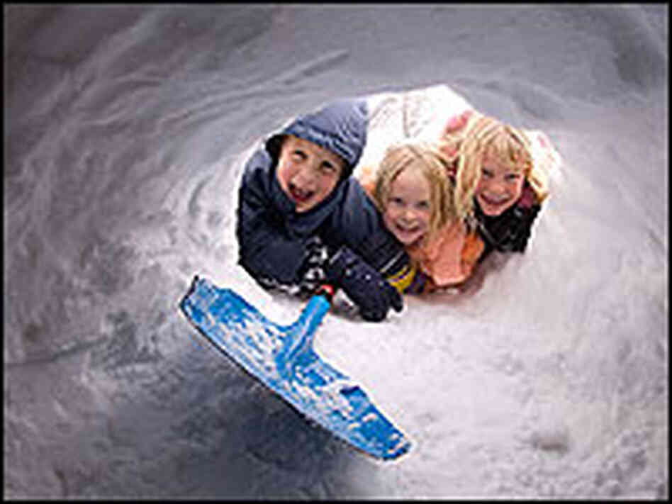 Skyler Bol(L), Bailey Lange(C) and Brice Lange look into a snow shelter Skyler Bol(L), Bailey Lange(C) and Brice Lange look into a snow shelter