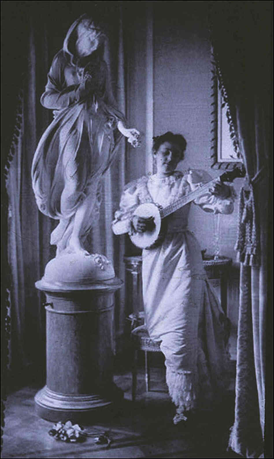 'Miss Apperson' playing banjo beside statue of Flora in niche of Sen. George Hearst's residence. 'Miss Apperson' playing banjo beside statue of Flora in niche of Sen. George Hearst's residence.