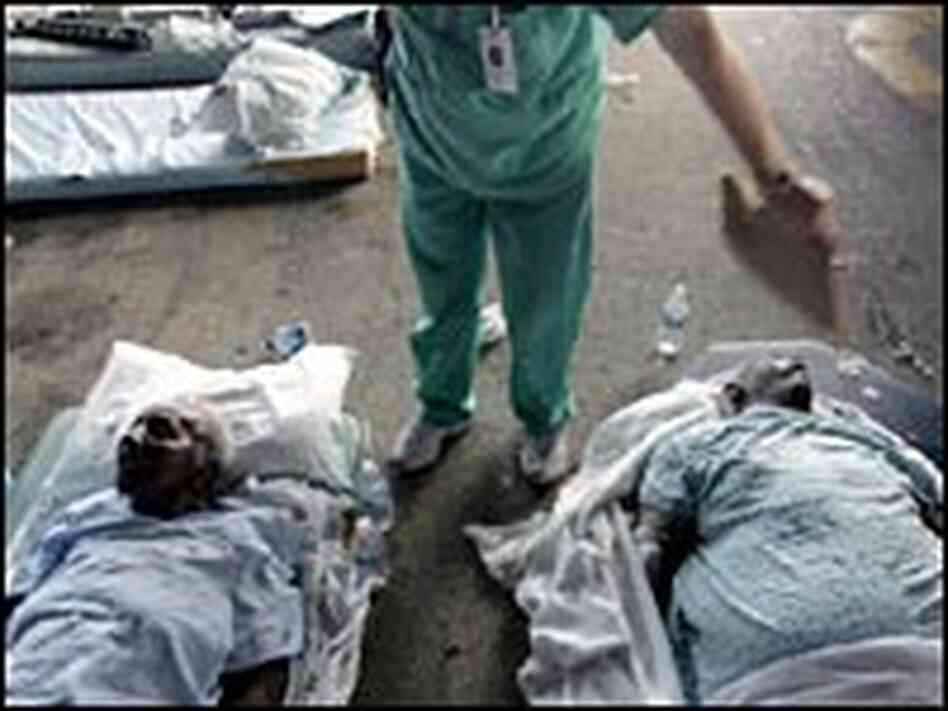 A nurse from New Orleans' Memorial Medical Center fans a patient waiting to be evacuated, 9/1/05.