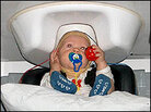 A baby's head rests inside an M.E.G. A baby's head rests inside an M.E.G.