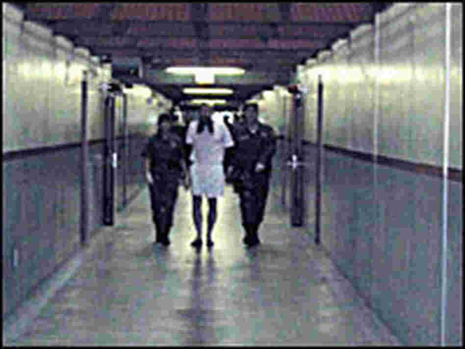Guards escort an prisoner out of his solitary-confinement cell Guards escort an prisoner out of his solitary-confinement cell