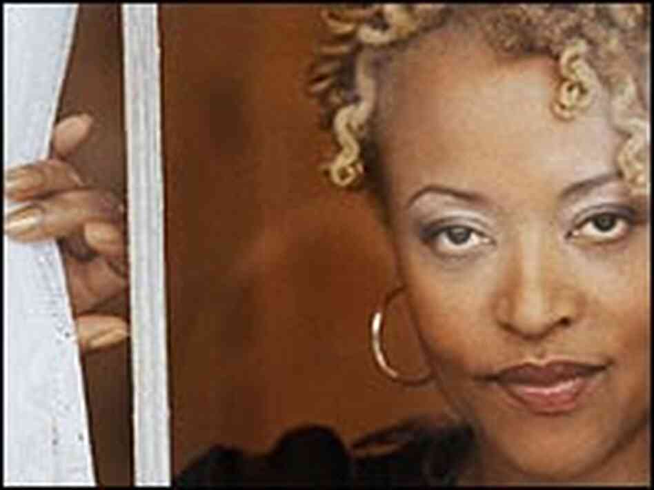 A closeup image of Cassandra Wilson looking through a window.