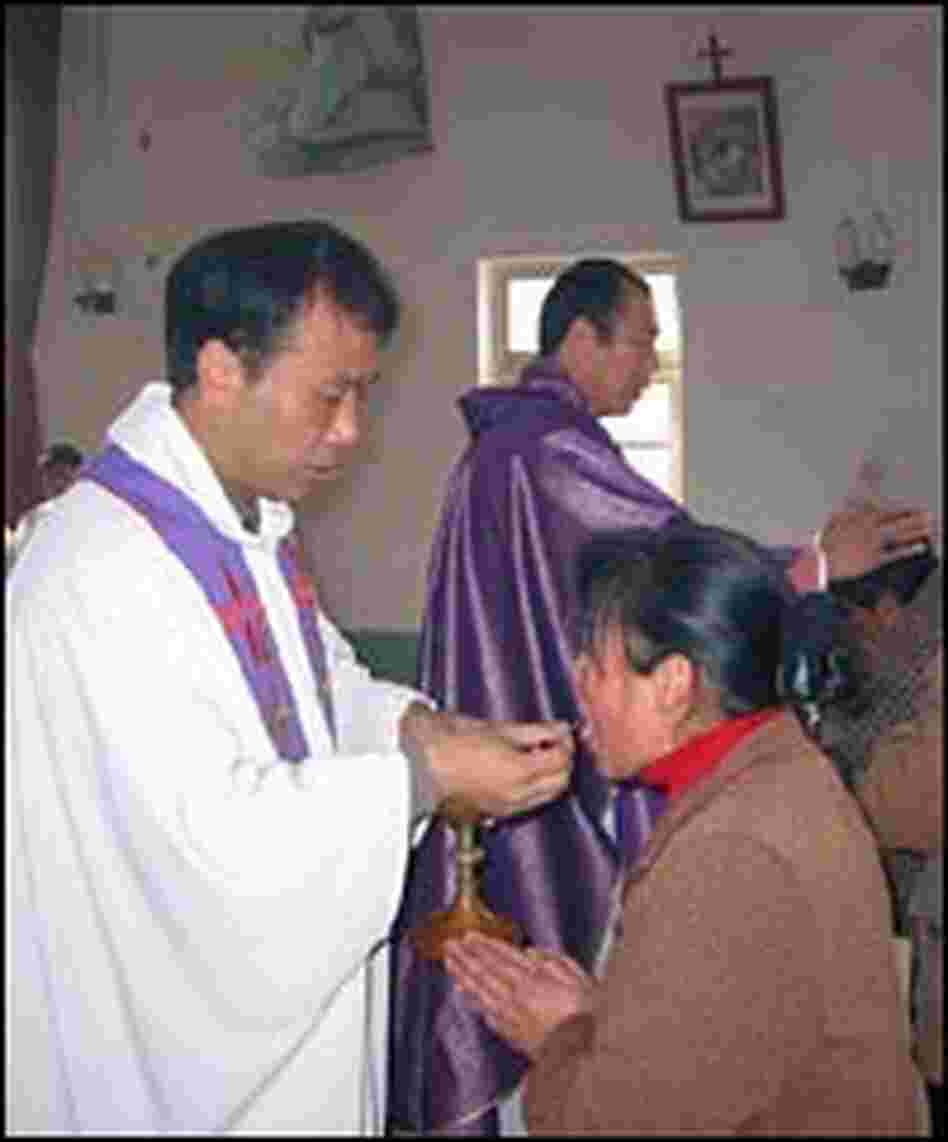 Bishop Feng and a local priest distribute the Eucharist.
