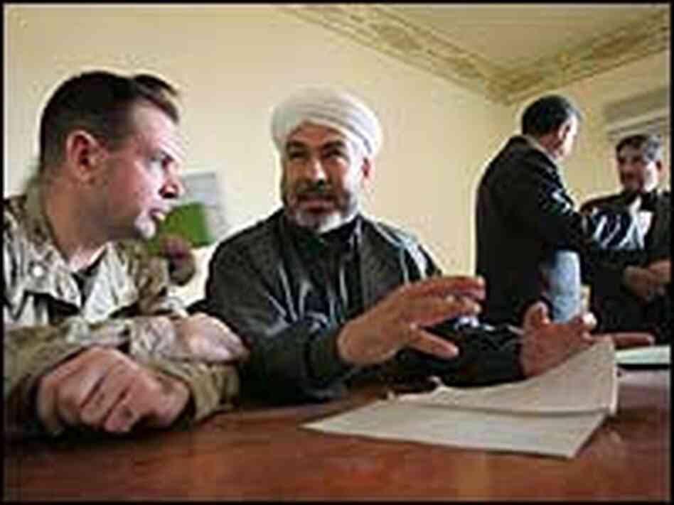 A U.S. Marine meets with a chairman of the Fallujah city council. A U.S. Marine meets with a chairman of the Fallujah city council.