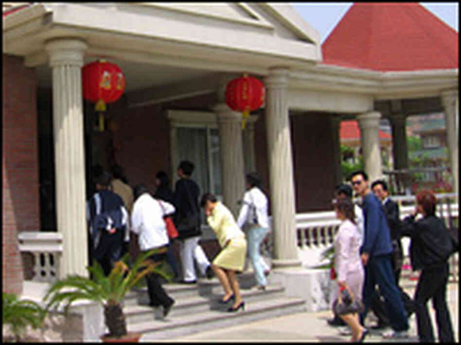A tour group enter a "typical" Huaxi residence.