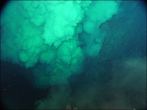A giant, eruptive plume pours out of "Brimstone Pit" crater near the summit of NW Rota-1 volcano,