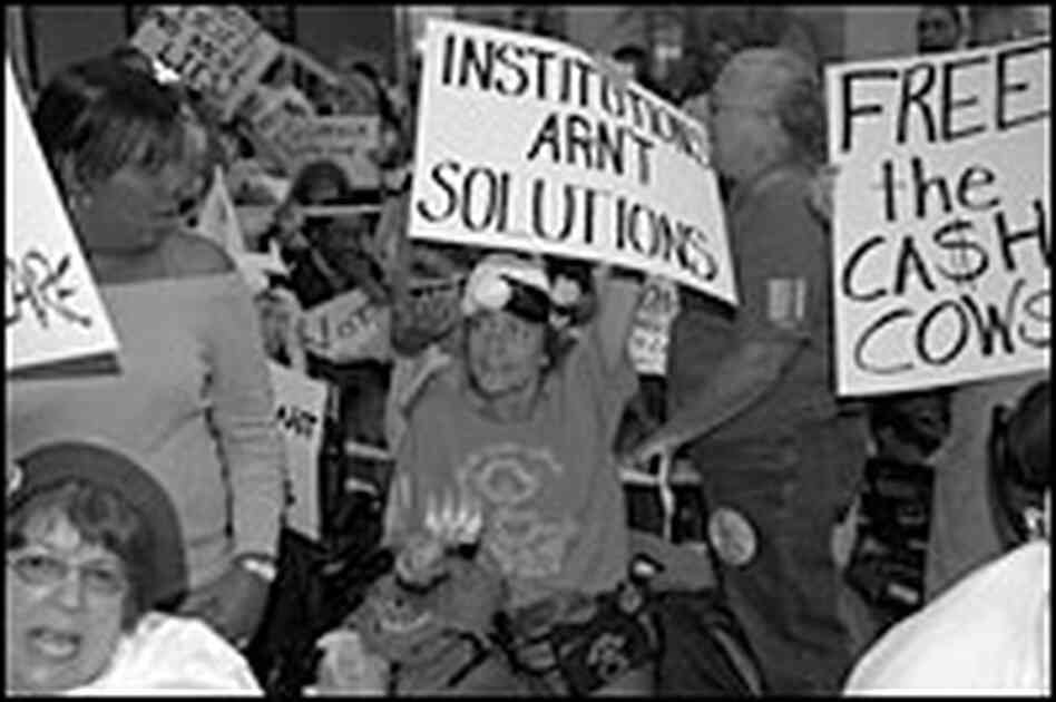 Protesters hold signs in the lobby of the Hilton Hotel Protesters hold signs in the lobby of the Hilton Hotel