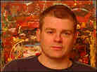 Mark Haddon stands in front of an abstract painting. Mark Haddon stands in front of an abstract painting.