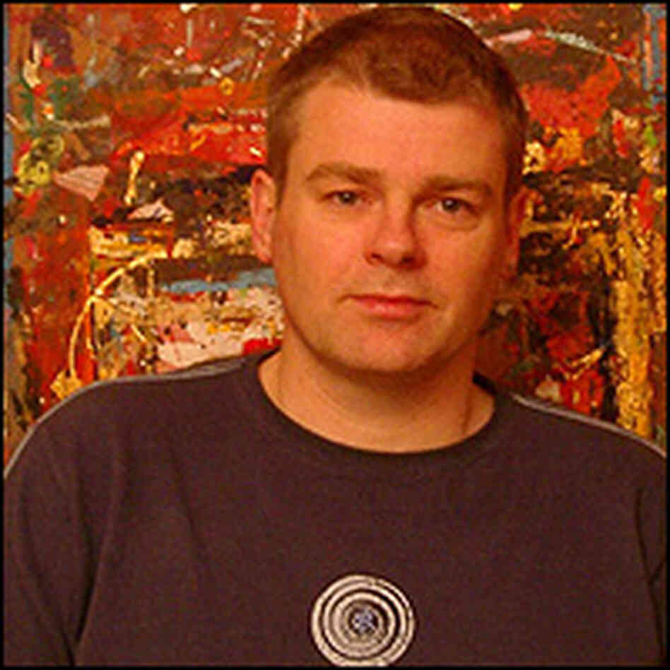 Mark Haddon stands in front of an abstract painting.