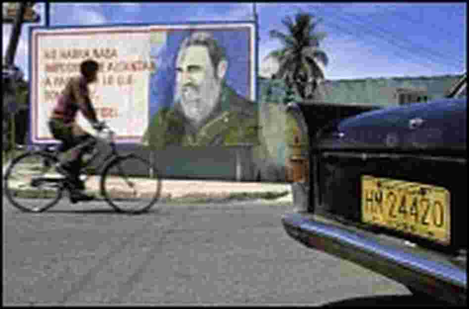 A bicyclist in 1994 rides past a billboard in Havana.