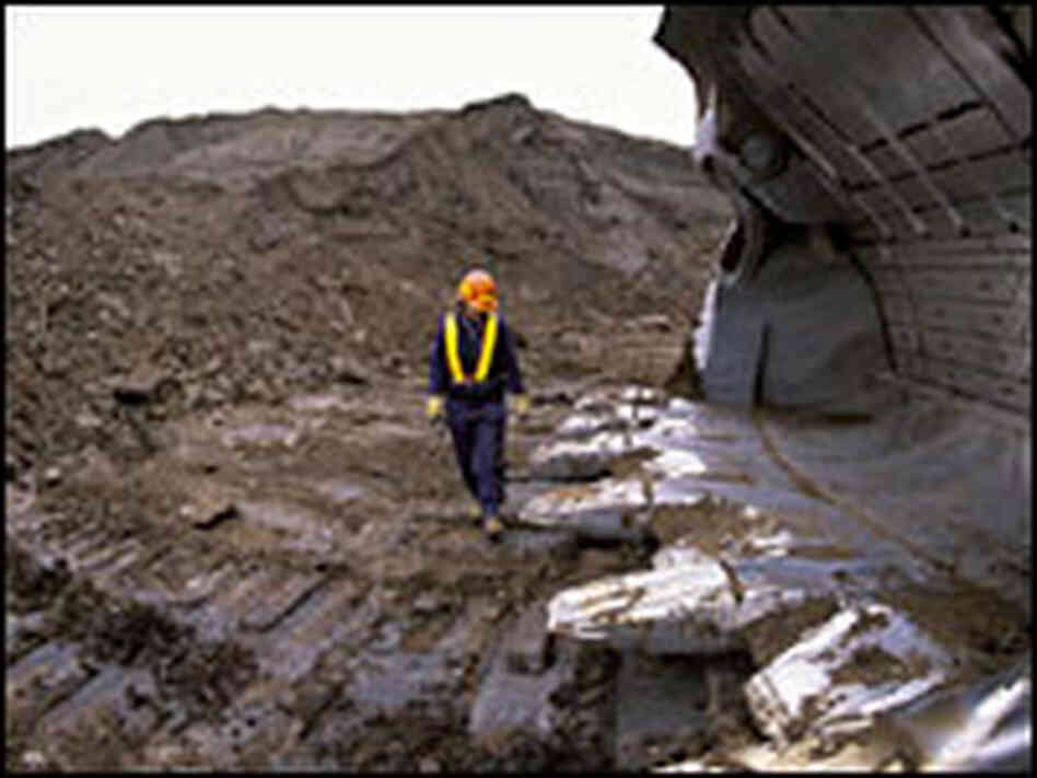 Man Standing in Oil Pit with Giant Shovel