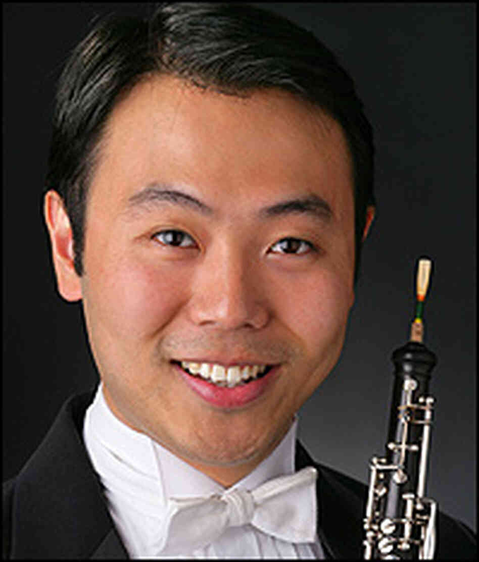 Liang Wang, pictured in tuxedo, holding his oboe.