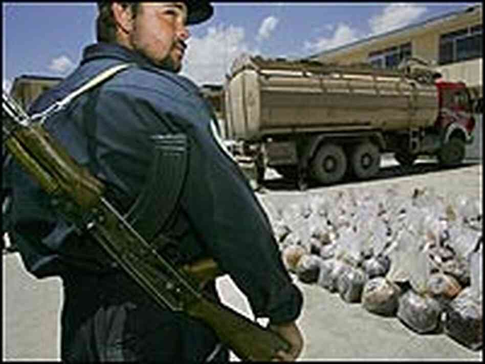 An Afghan Counter Narcotics Police officer guarding plastic bags of opium siezed from a fuel tanker. An Afghan Counter Narcotics Police officer guarding plastic bags of opium siezed from a fuel tanker.