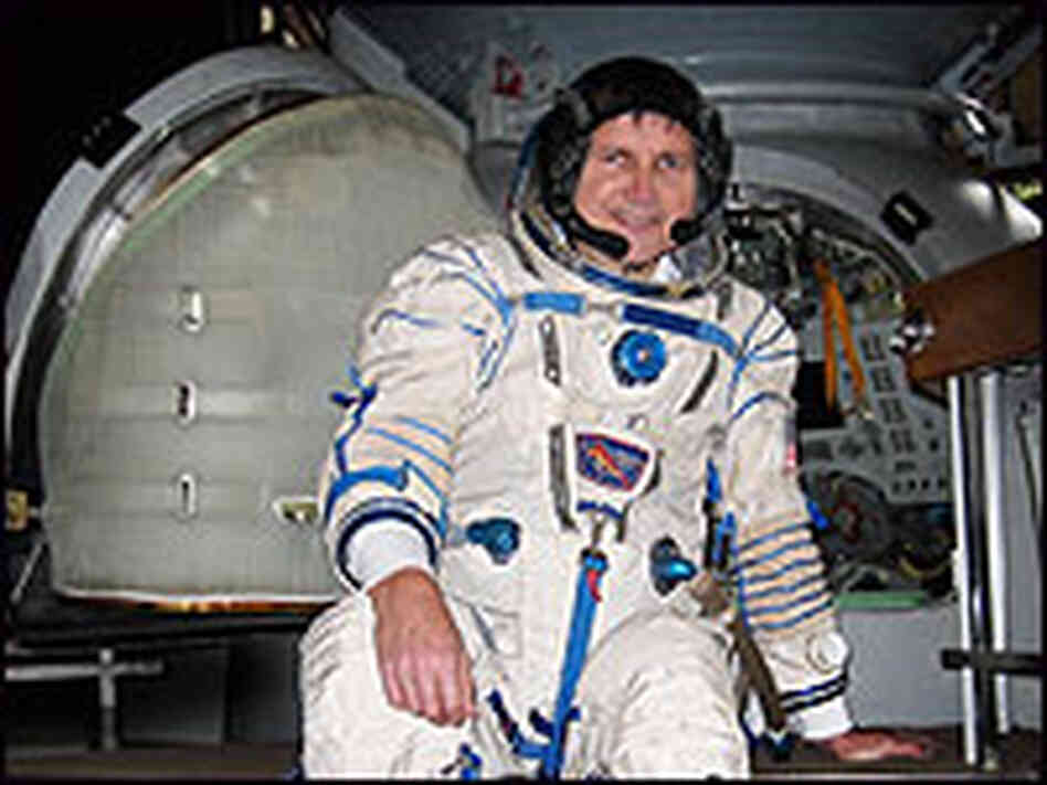 Charles Simonyi, in astronaut gear, in front of the Soyuz simulator.