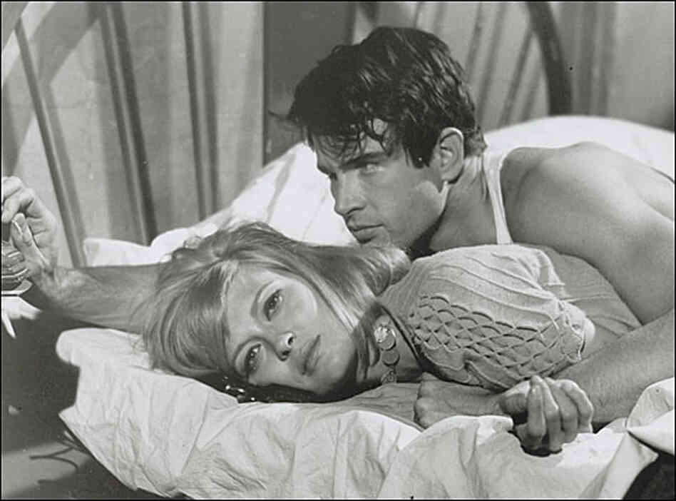 Faye Dunaway and Warren Beatty sprawl on a bed