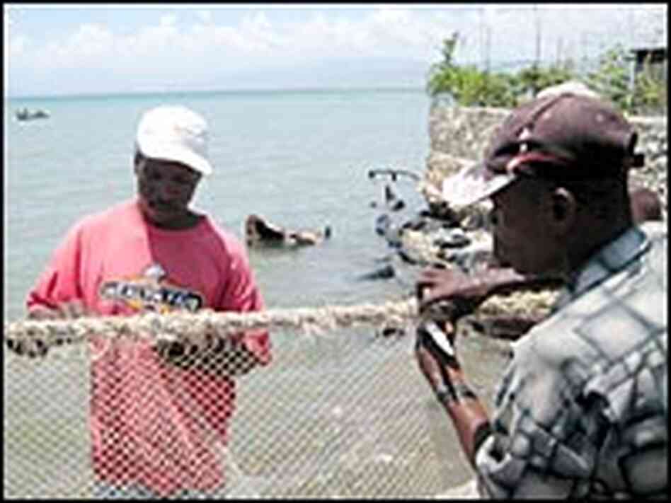 Fishermen sing as they mend a fishing net in Cite Soleil.