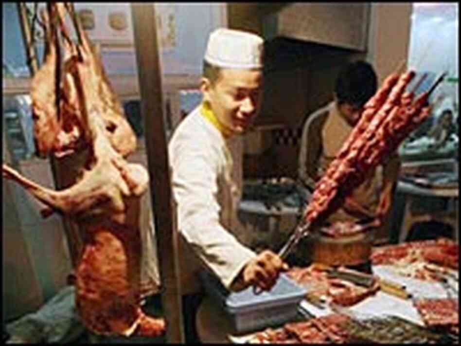 A Chinese Muslim cook prepares kebabs for Middle Eastern residents