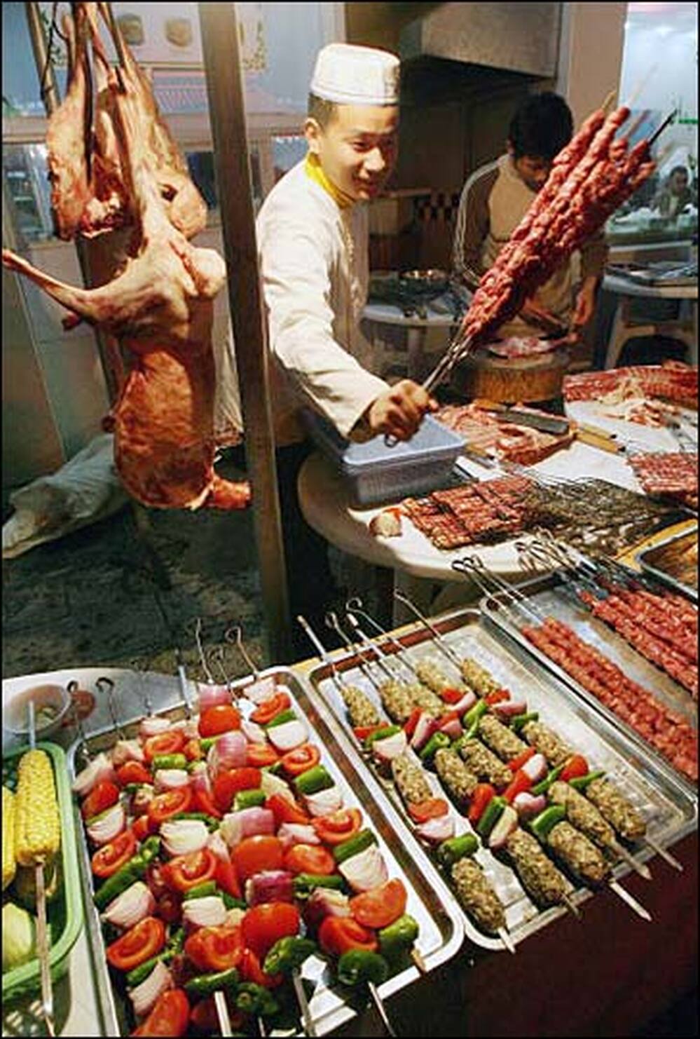 A Chinese Muslim cook prepares kebabs for Middle Eastern residents